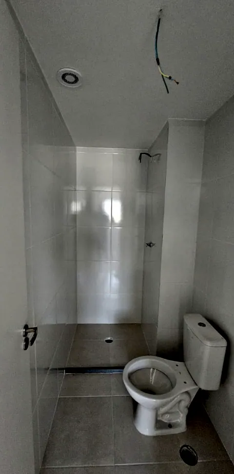 Antes: banheiro branco com vaso e chuveiro