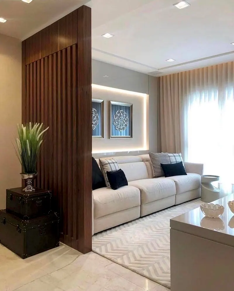 Sala com divisória de madeira ripada, sofá claro e cortina