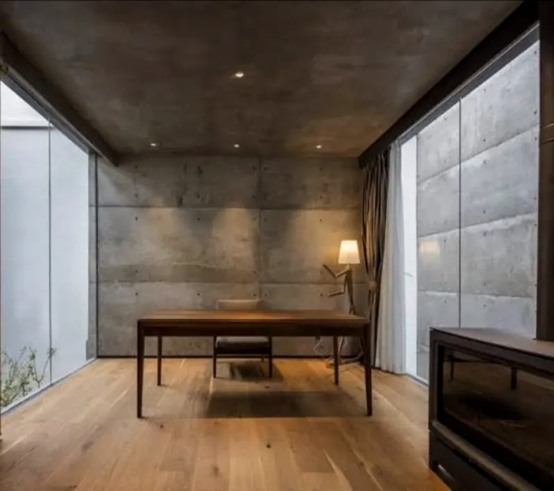 Projeto de sala com mesa de trabalho, parede cinza e painel estofado