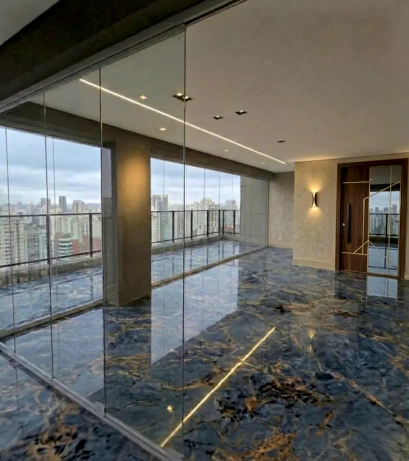 Varanda envidraçada com piso de mármore azul escuro com veios dourados e vista da cidade
